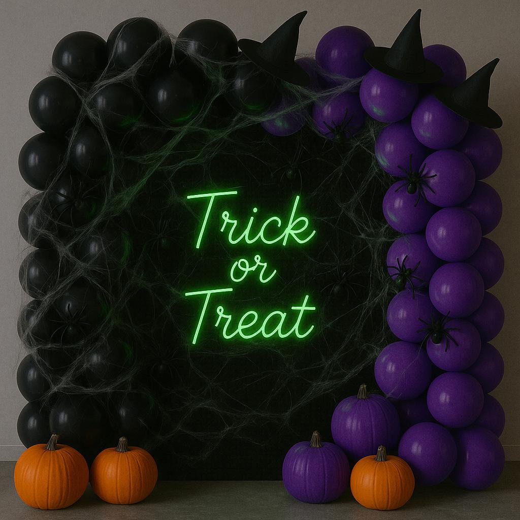 Halloween balloon display in black and green theme with "Trick or Treat" sign
